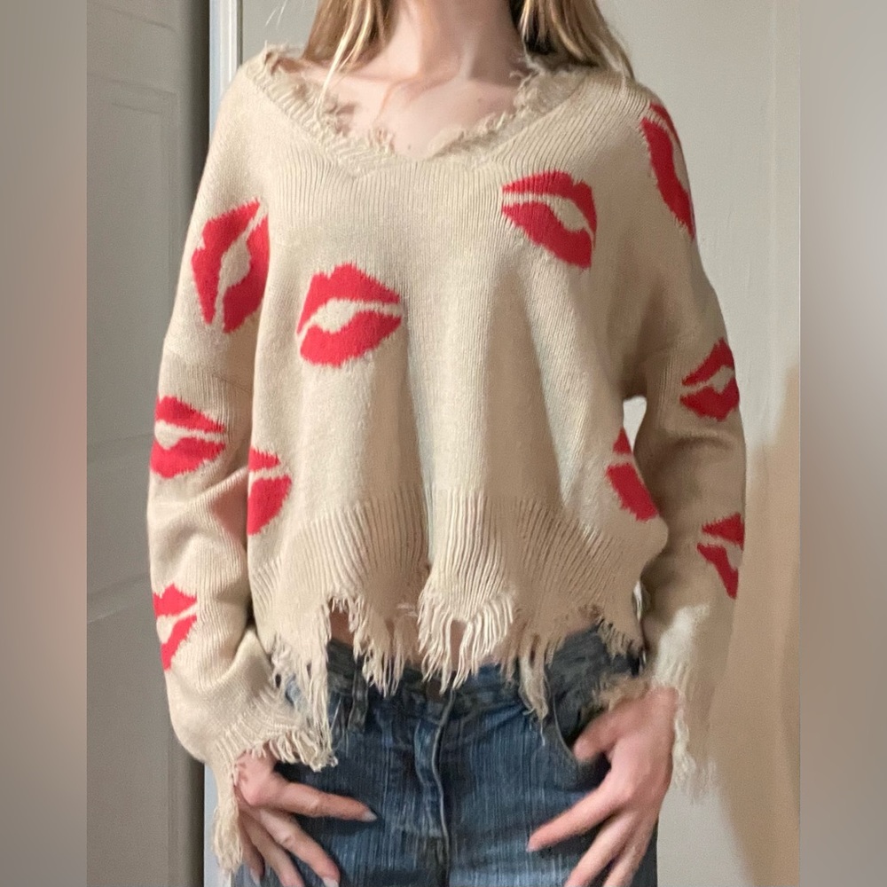 Frayed sweater with lip pattern.